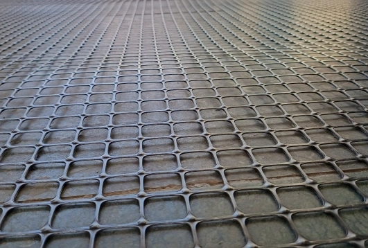 Close-up view of a black biaxial geo grid mesh used for soil reinforcement and ground stabilization in construction and civil engineering projects.
