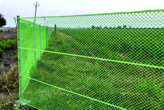 green ure safety netting installed outdoors on fence posts