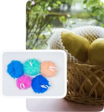 fruits wrapped in white protective foam netting in a basket, alongside a group of colorful mesh bath loofahs