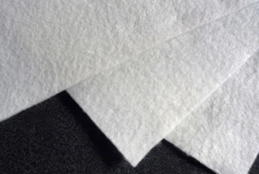 White nonwoven geotextile fabric sheet used in industrial filtration and manufacturing applications