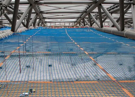 Fall protection safety net installed beneath working level at a construction site to prevent worker falls