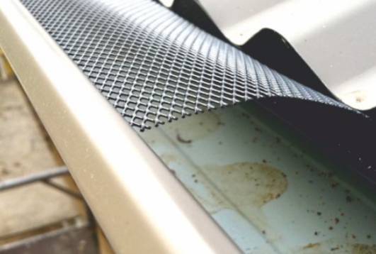 Gutter guard mesh installed on construction gutters, preventing debris and water blockage, supplied by Indonet Group