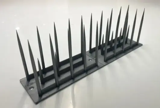 grey plastic anti-bird spikes designed to prevent pigeons and other birds from landing on ledges and roofs.